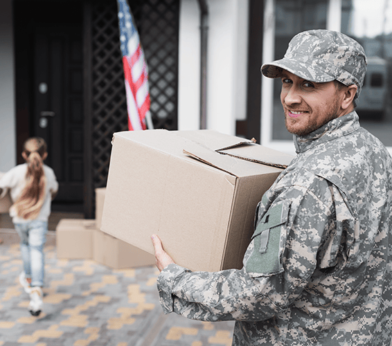 soldier carrying a box to a house